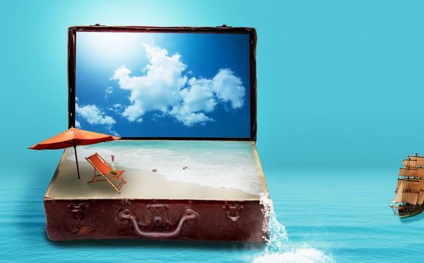 Zdjęcie laptopa leżącega na walizce podróżnej